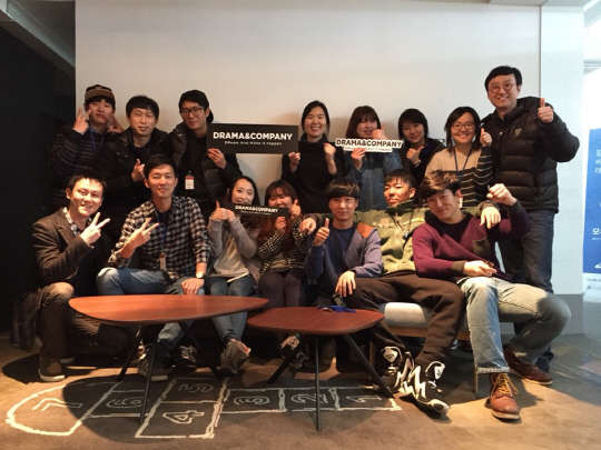 최재호 드라마앤컴퍼니 대표(두번째 줄 맨 오른쪽)를 비롯한 회사 직원들이 파이팅 구호를 외치며 서울 강남 삼성동에 위치한 본사에서 기념촬영을 하고 있다.  드라마앤컴퍼니 제공
